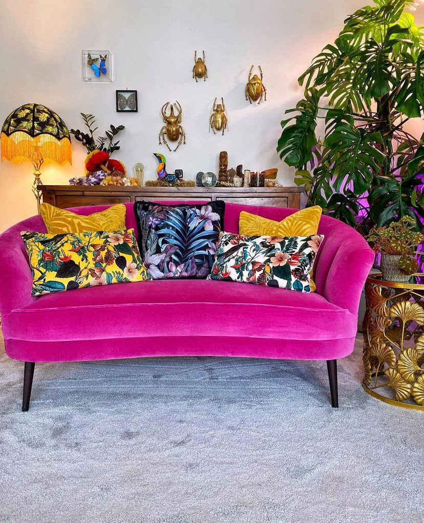 Sofa styling tips - This hot pink velvet sofa has been styled beautifully with colourful, patterned cushions.