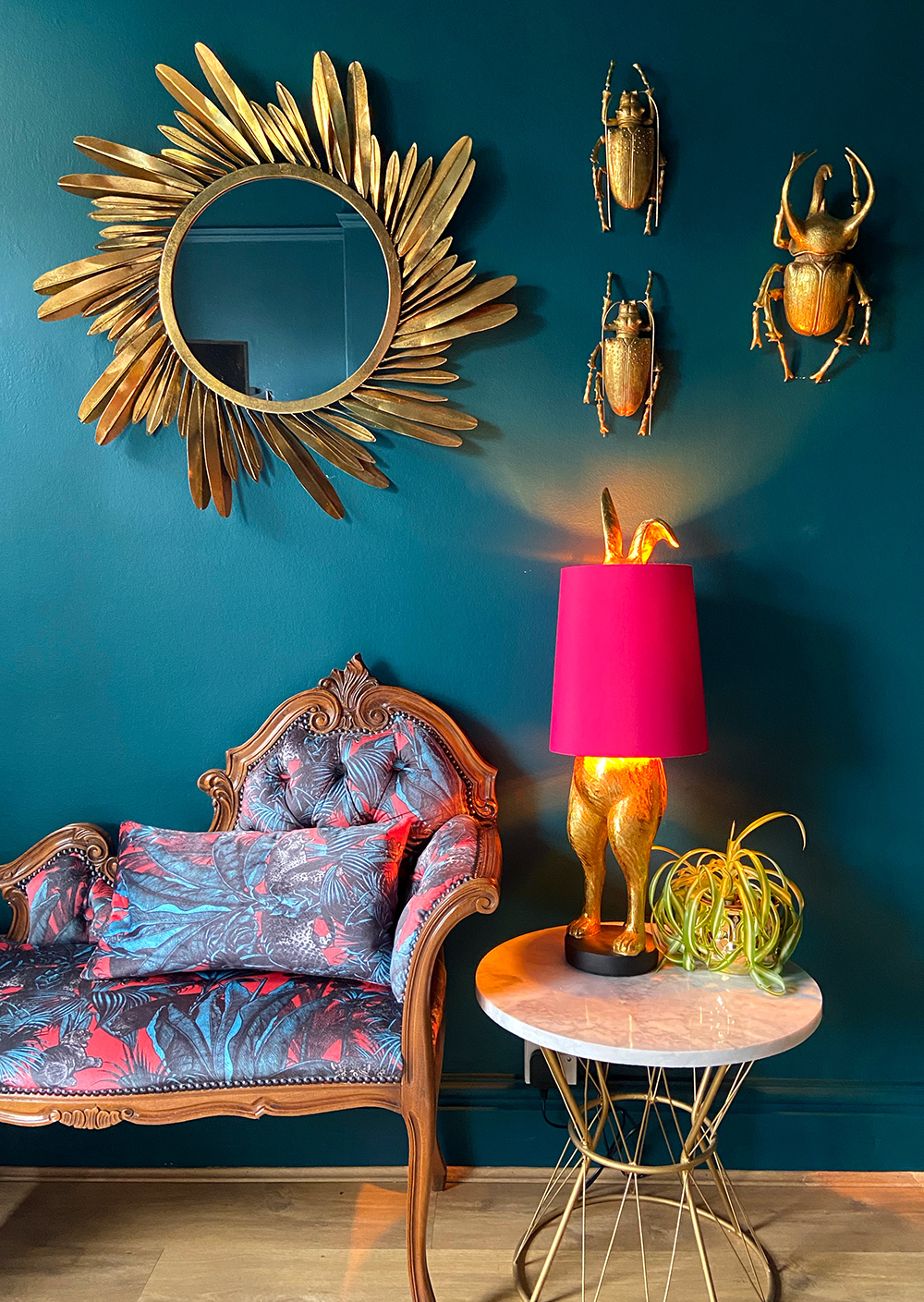 Quirky living room with dark blue walls, hot pink animal lamp and quirky wall decor like these fabulous gold beetles. All available from Audenza
