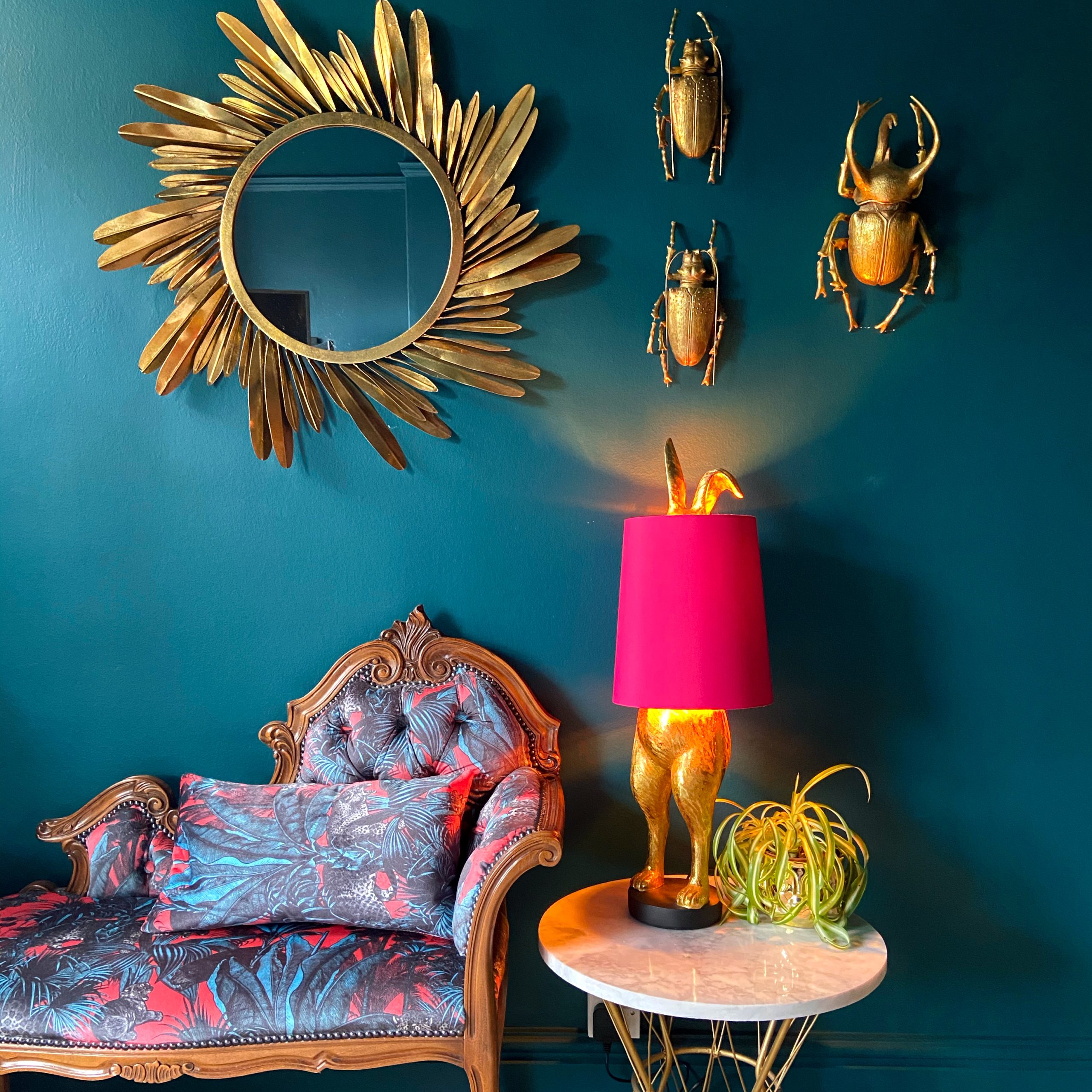 Quirky living room with dark blue walls, hot pink animal lamp and quirky wall decor like these fabulous gold beetles. All available from Audenza