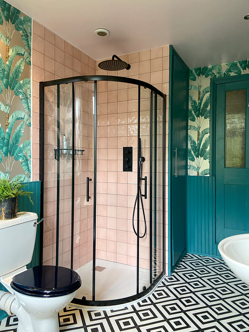 Tropical bathroom inspiration. Blush pink tiles paired with black shower enclosure, tropical patterned wallpaper and monochrome patterned floor
