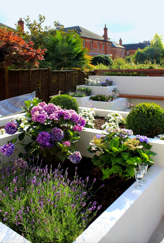Add interest by varying the heights and shapes of raised planting beds to create a sense of movement. 