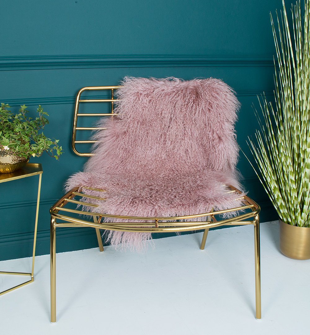 The pink sheepskin rug here, paired with the super gold chair is a perfect combo.