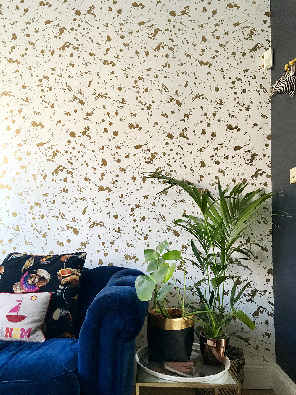 After: Living room makeover. Stylish and glamorous living room decor featuring Gold Drip wallpaper by Jonathan Adler.