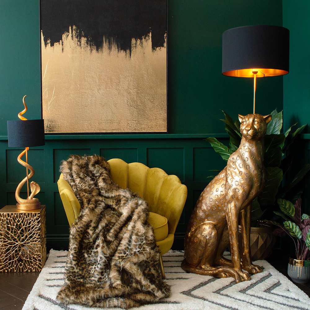 Moody green living room decor. Large leopard floor lamp with mustard velvet armchair and faux fur leopard print throw