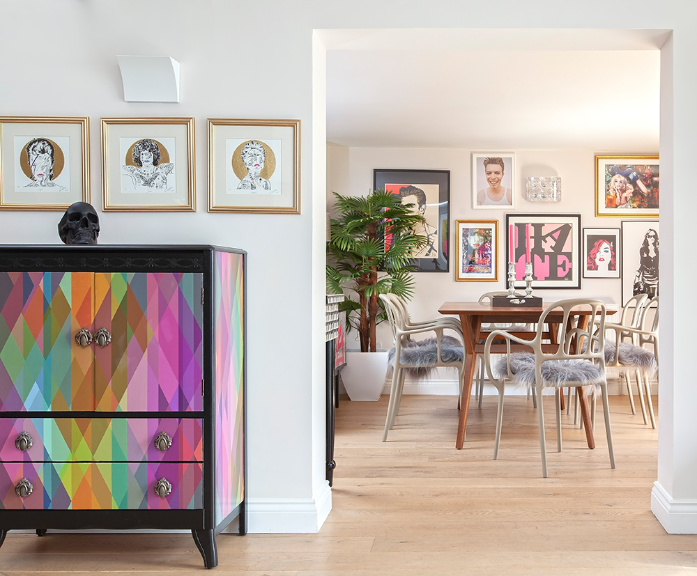 Eclectic living room with colourful furniture and unusual gallery wall.