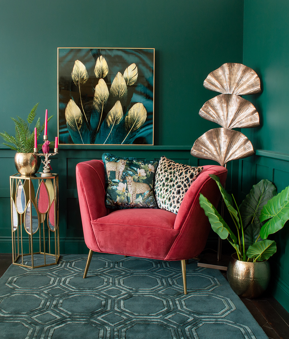 Green living room with gorgeous jewel colours. Pink velvet armchair with teal patterned cushions and gold furniture