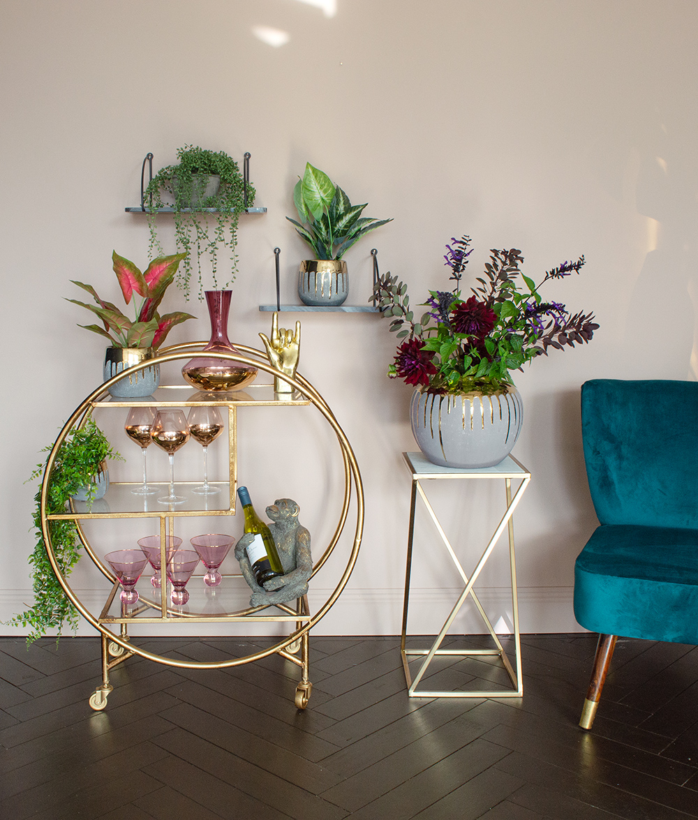 Blush pink living room decor. Gold round drinks trolley styled with pink glasses and pink decanter for a glamorous home bar set up!