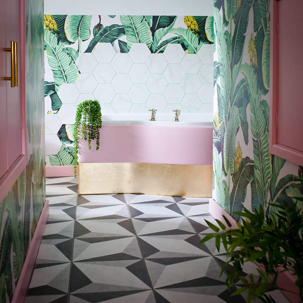 Pink and green tropical bathroom decor. Banana leaf wallpaper with monochrome patterned floor tiles