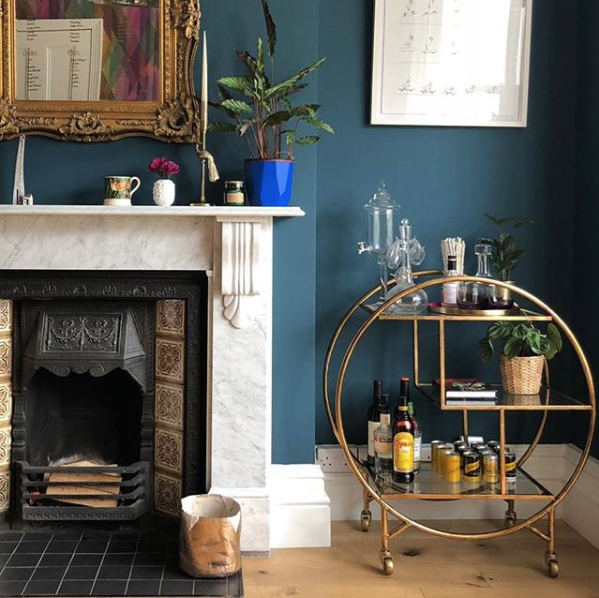 Dark and moody living room with gold luxe drinks trolley by Audenza. Image by @southlondonhome