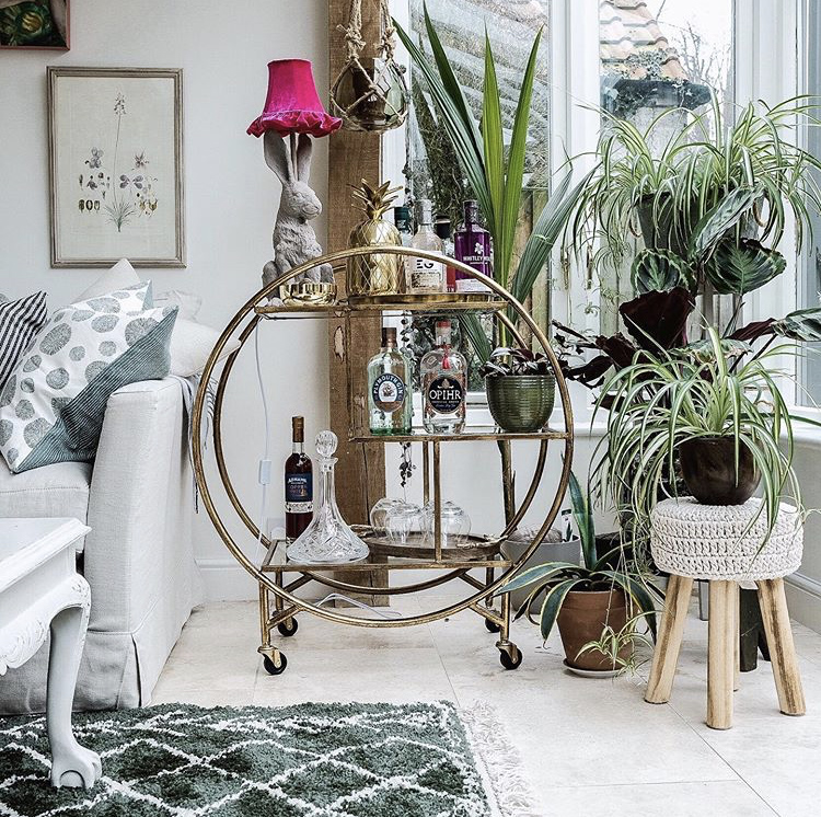 Beautiful drinks trolley styling with lots of lush house plants. Gold Luxe Round Drinks Trolley from Audenza.