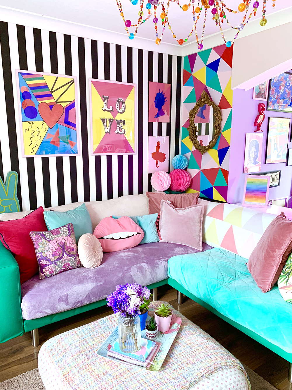 Crazy & colourful living room decor with monochrome stripy wallpaper and quirky colour pops.