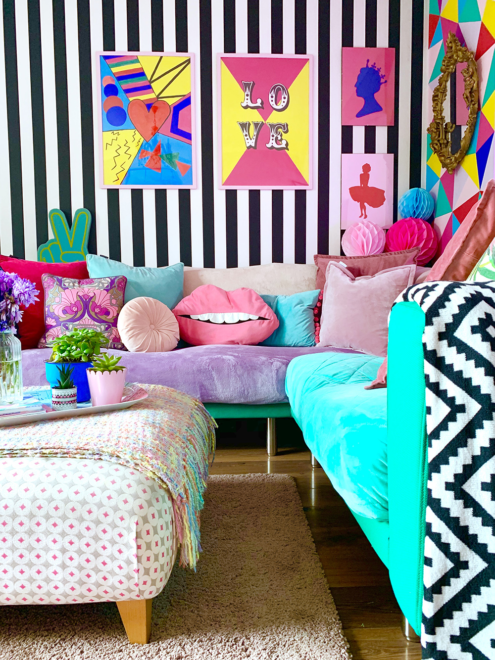 Crazy & colourful living room decor with monochrome stripy wallpaper and quirky colour pops.