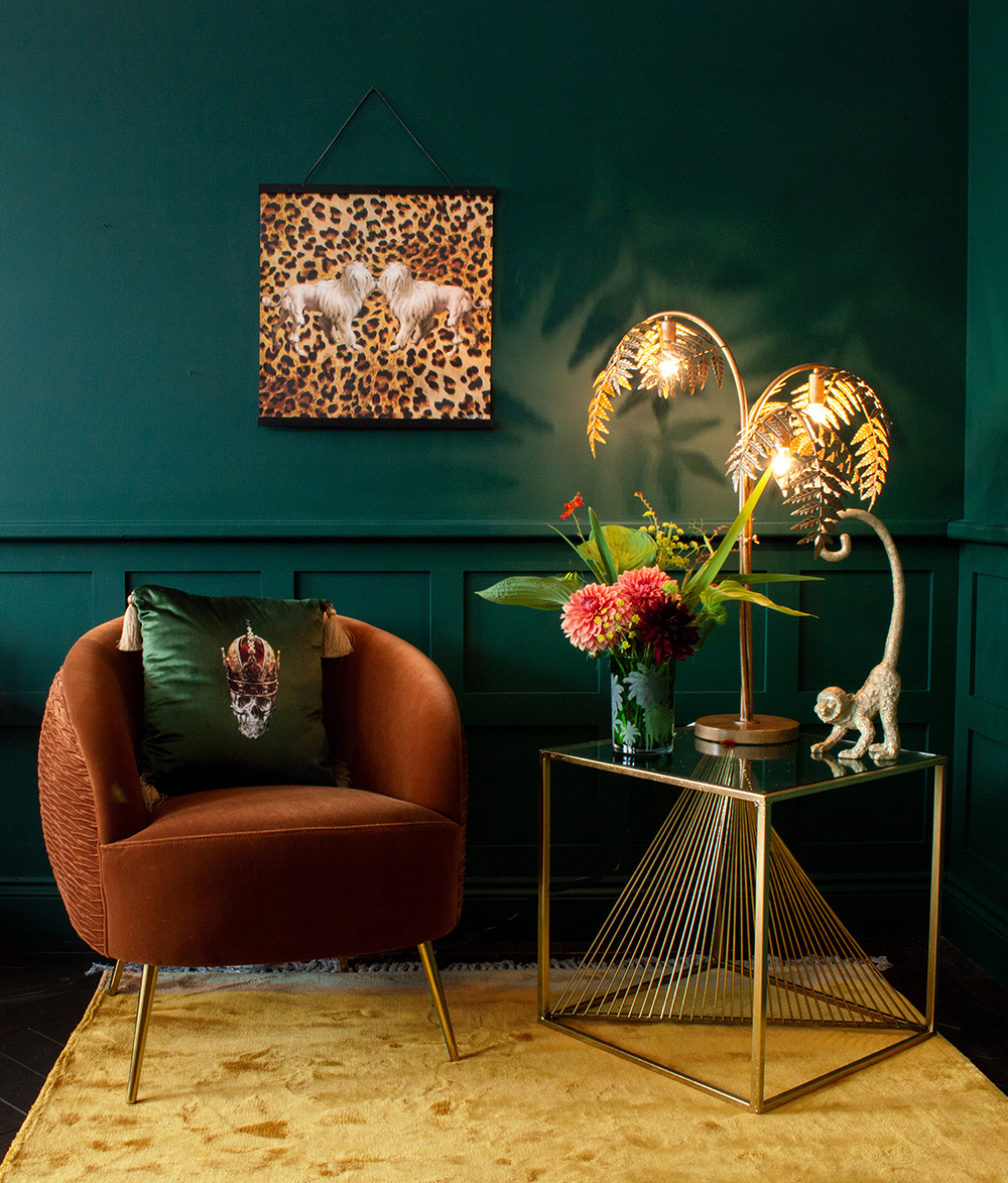 Dark and moody green walls, paired with rich autumnal coloured furniture and home accessories