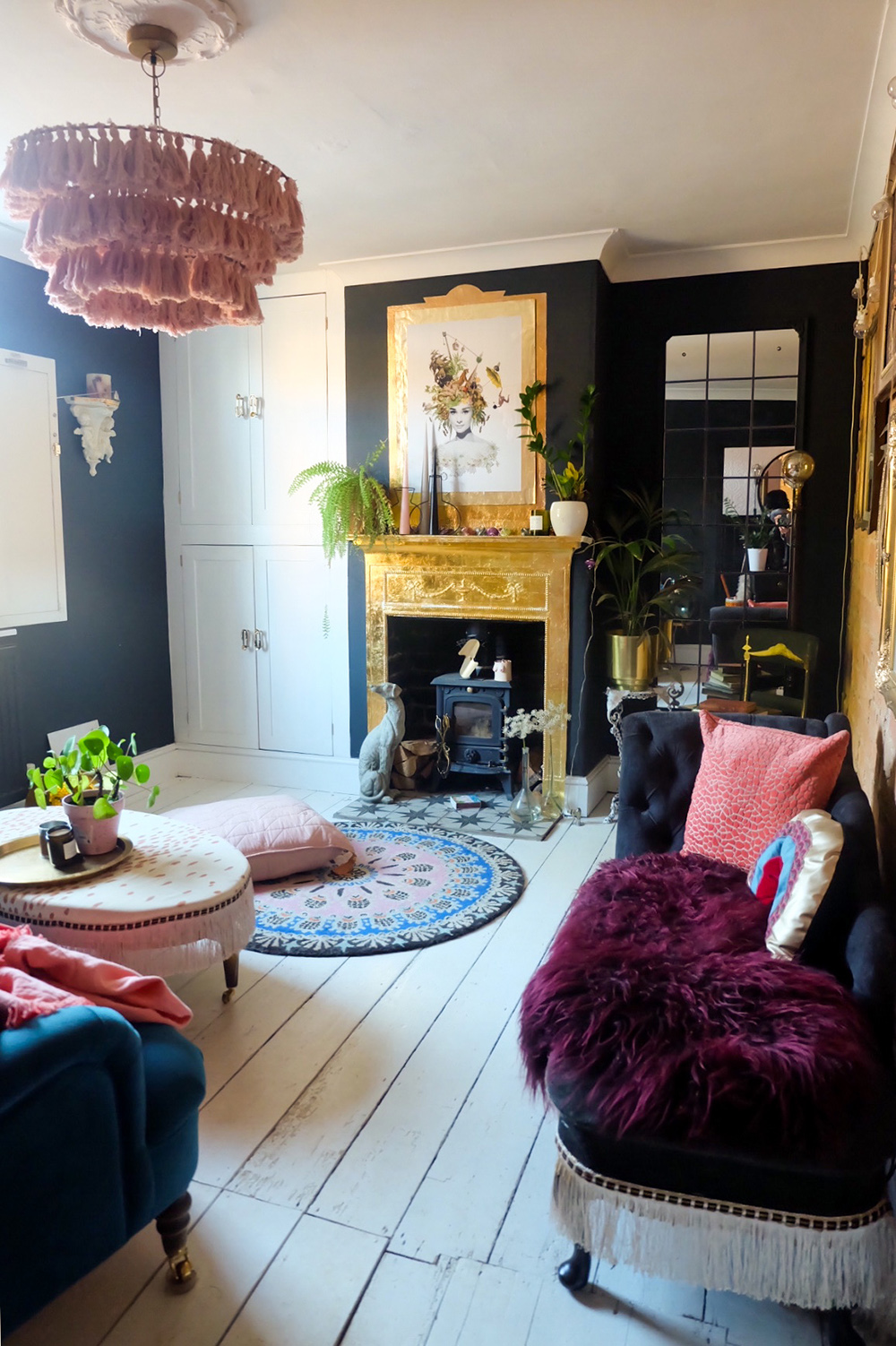 Before and after - eclectic living room decor with black walls and gold fireplace.