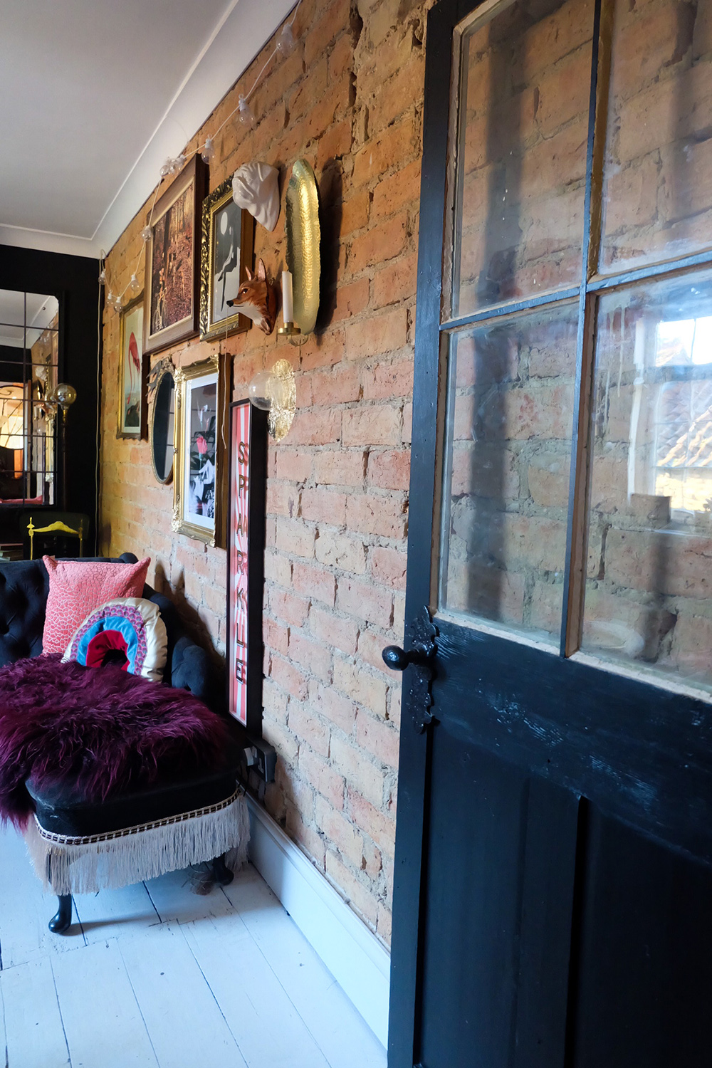 Eclectic living room with exposed brick feature wall.