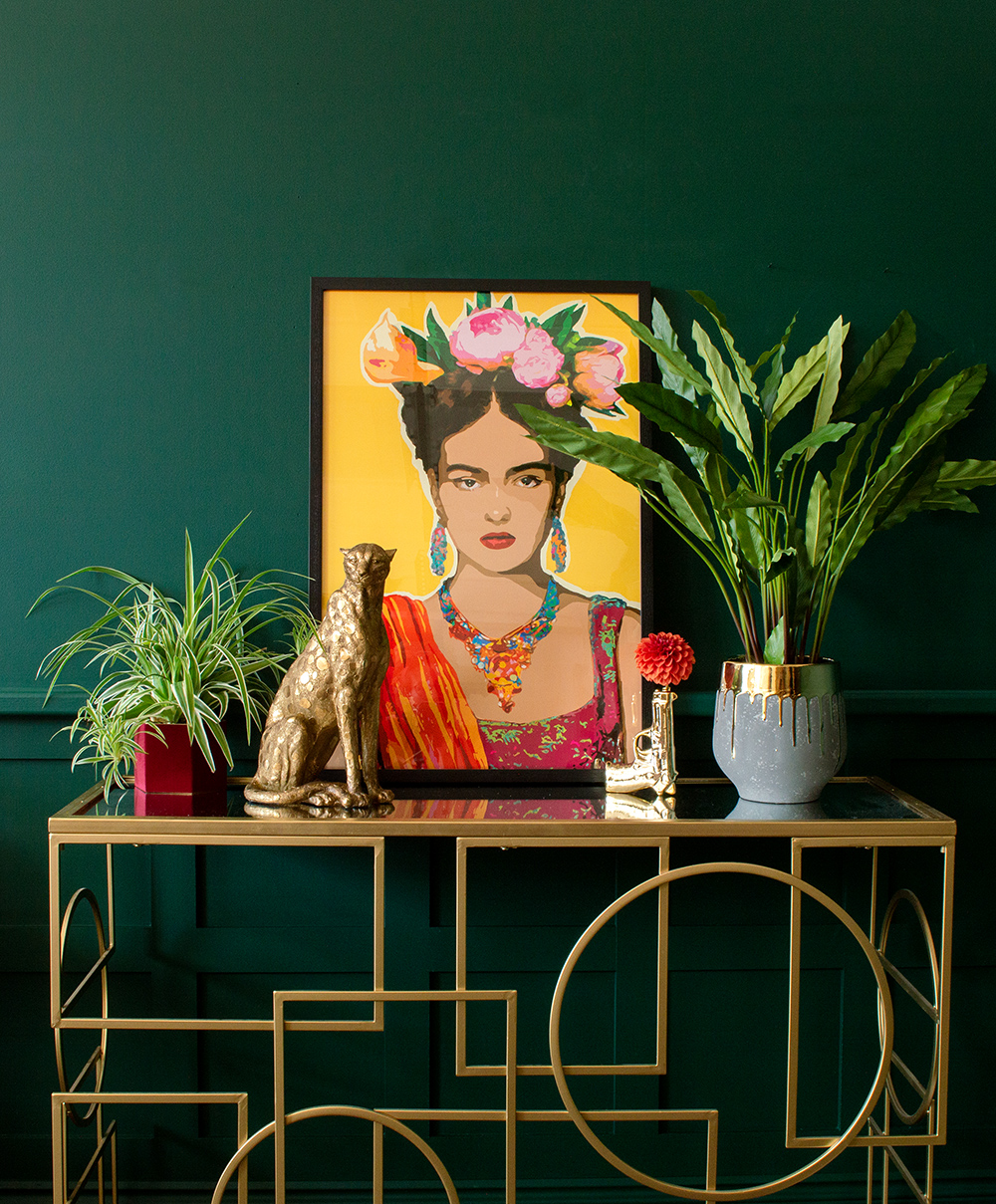 Moody, green living room decor with colourful and bold Frida Kahlo style self portrait