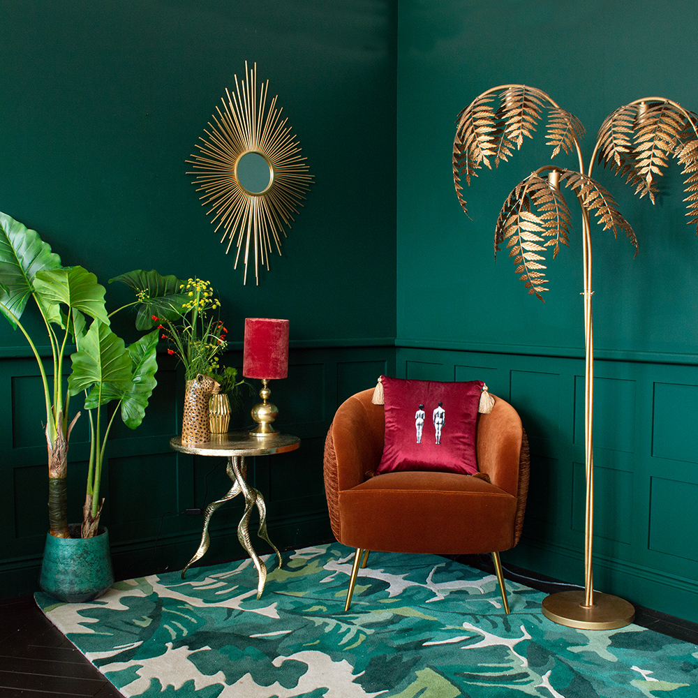 Green, tropical living room with palm leaf floor lamp.