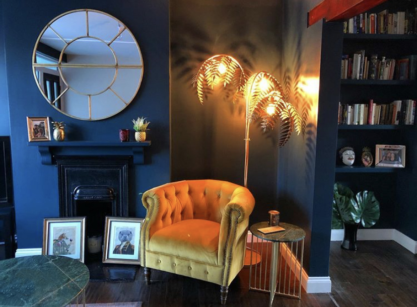 Dark and moody decor inspiration - our bronze palm leaf floor lamp styled beautifully in a navy living room. 