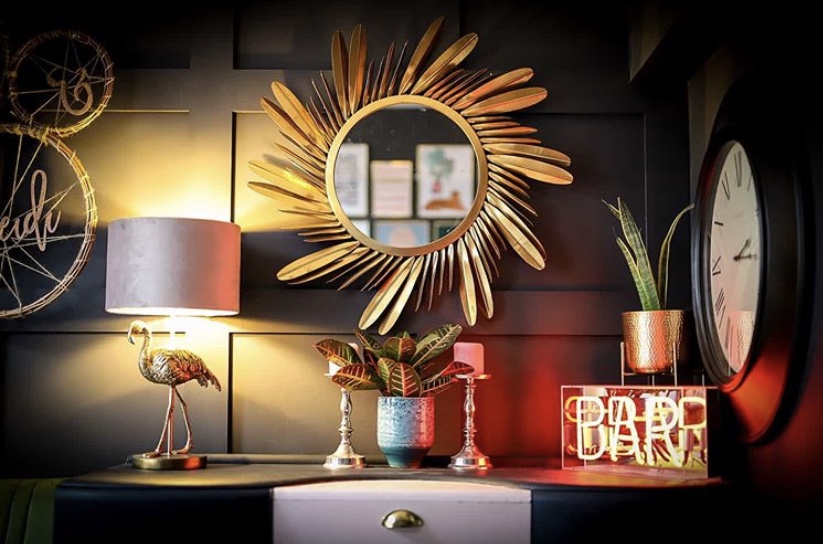 Dark and moody living room styled with our golden feather mirror