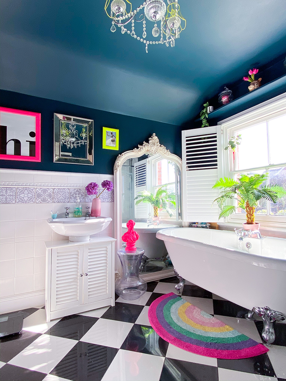 The main bathroom in this fun family home with with claw foot bathtub and quirky, neon pops of colour