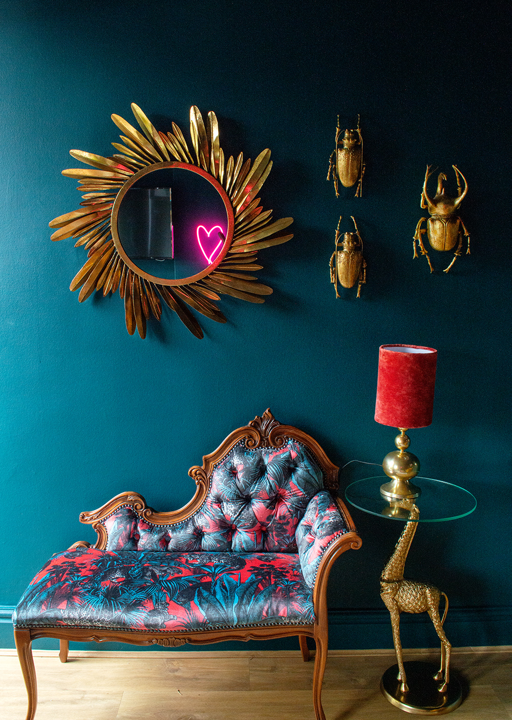 Eclectic, moody living room with golden feather mirror and quirky insect wall beetles.