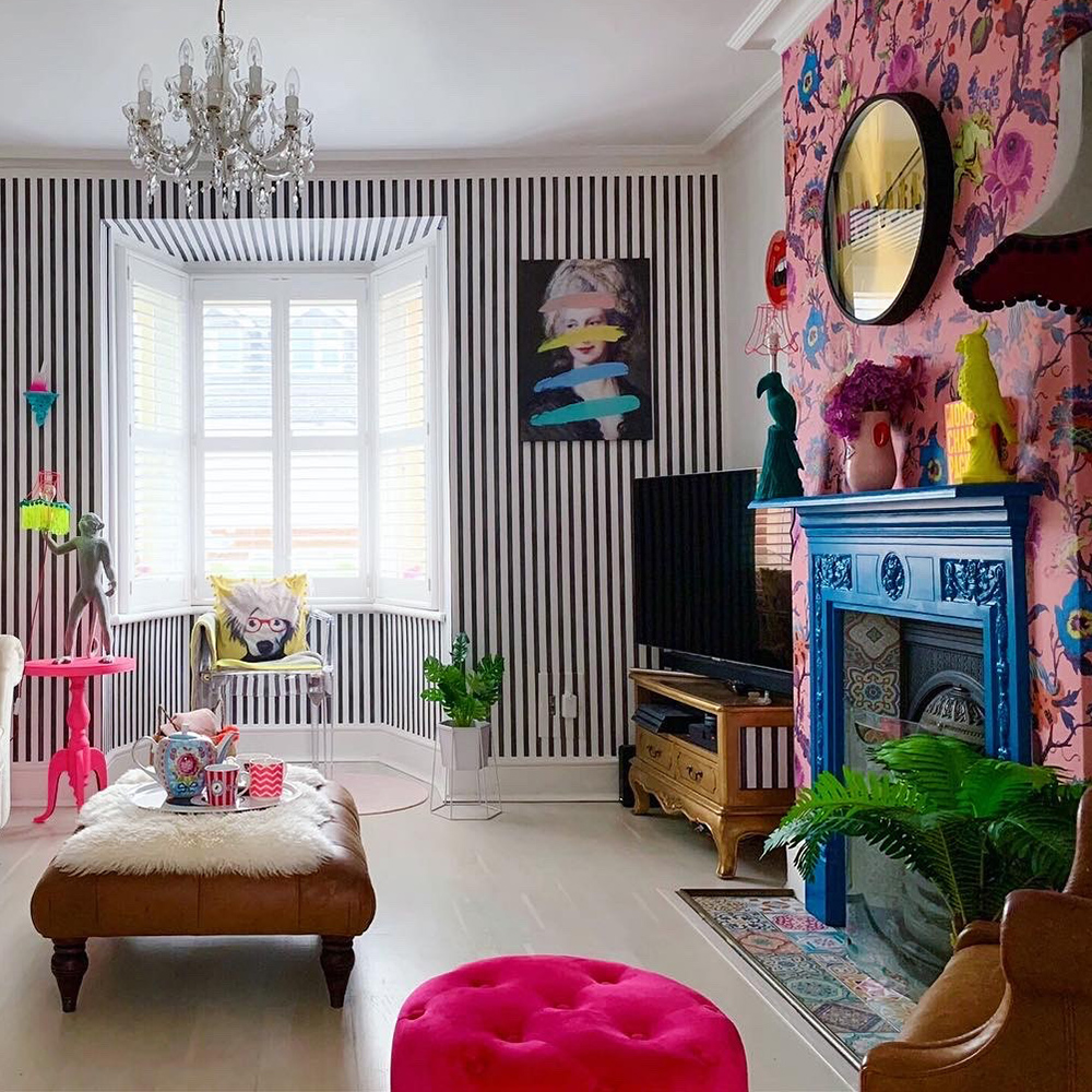 Quirky living room with colourful, clashing patterned wallpaper and cobalt blue fireplace