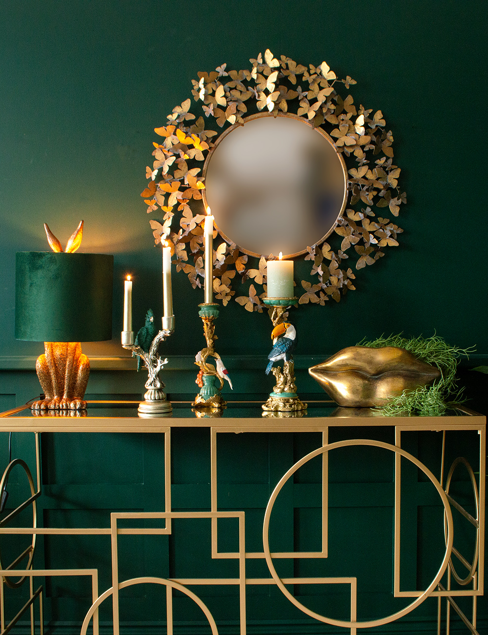 Glamorous, gold living room inspiration. Moody, dark green walls, paired with gold accessories, gold console table and quirky animal lamp. All available at Audenza