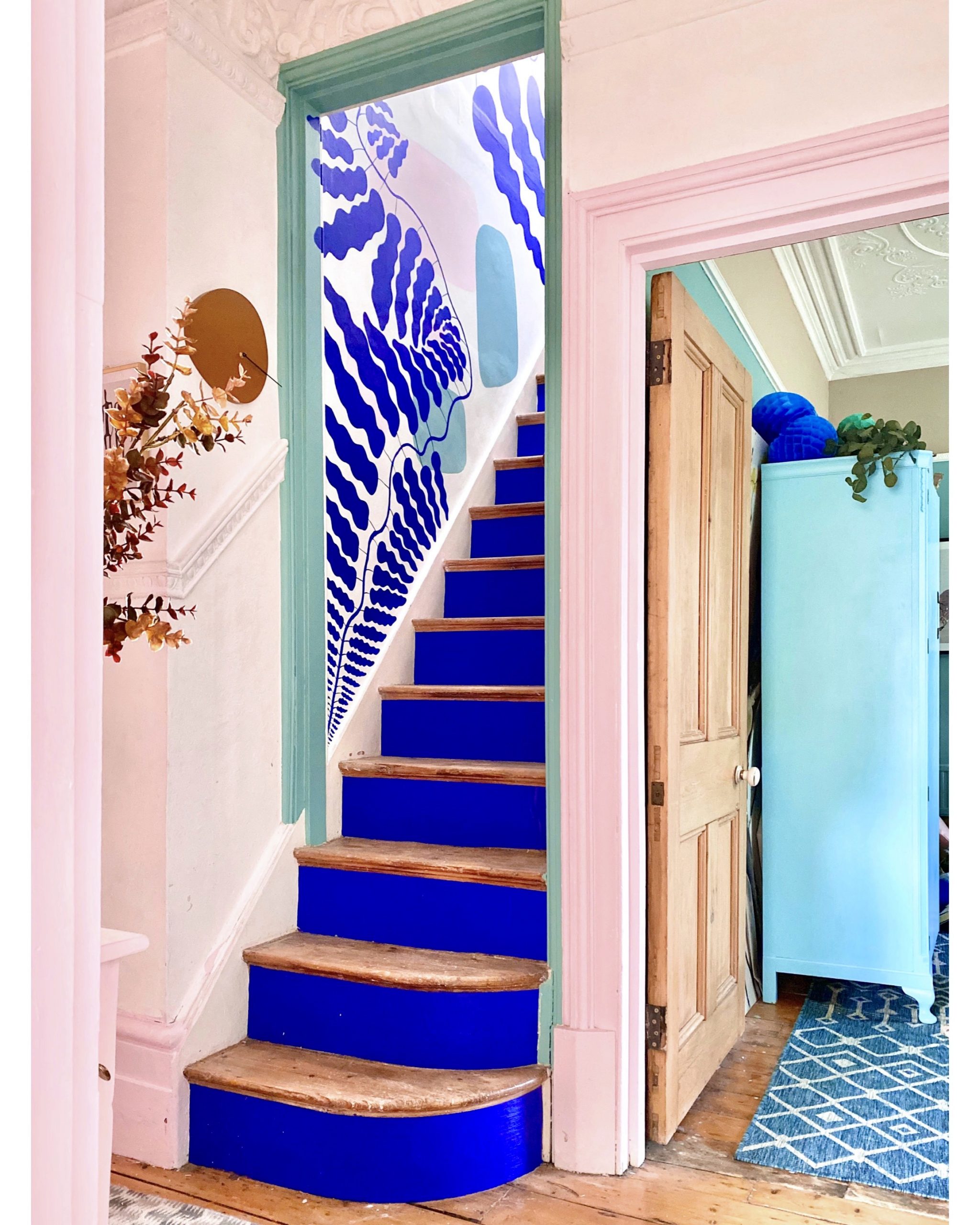 House tour of stunning London home with pastel hues and colourful wall murals - blush pink and cobalt blue hallway