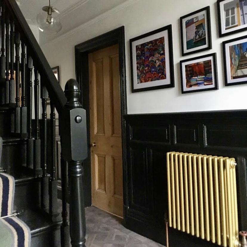 Monochrome black and white hallway with metallic gold radiator