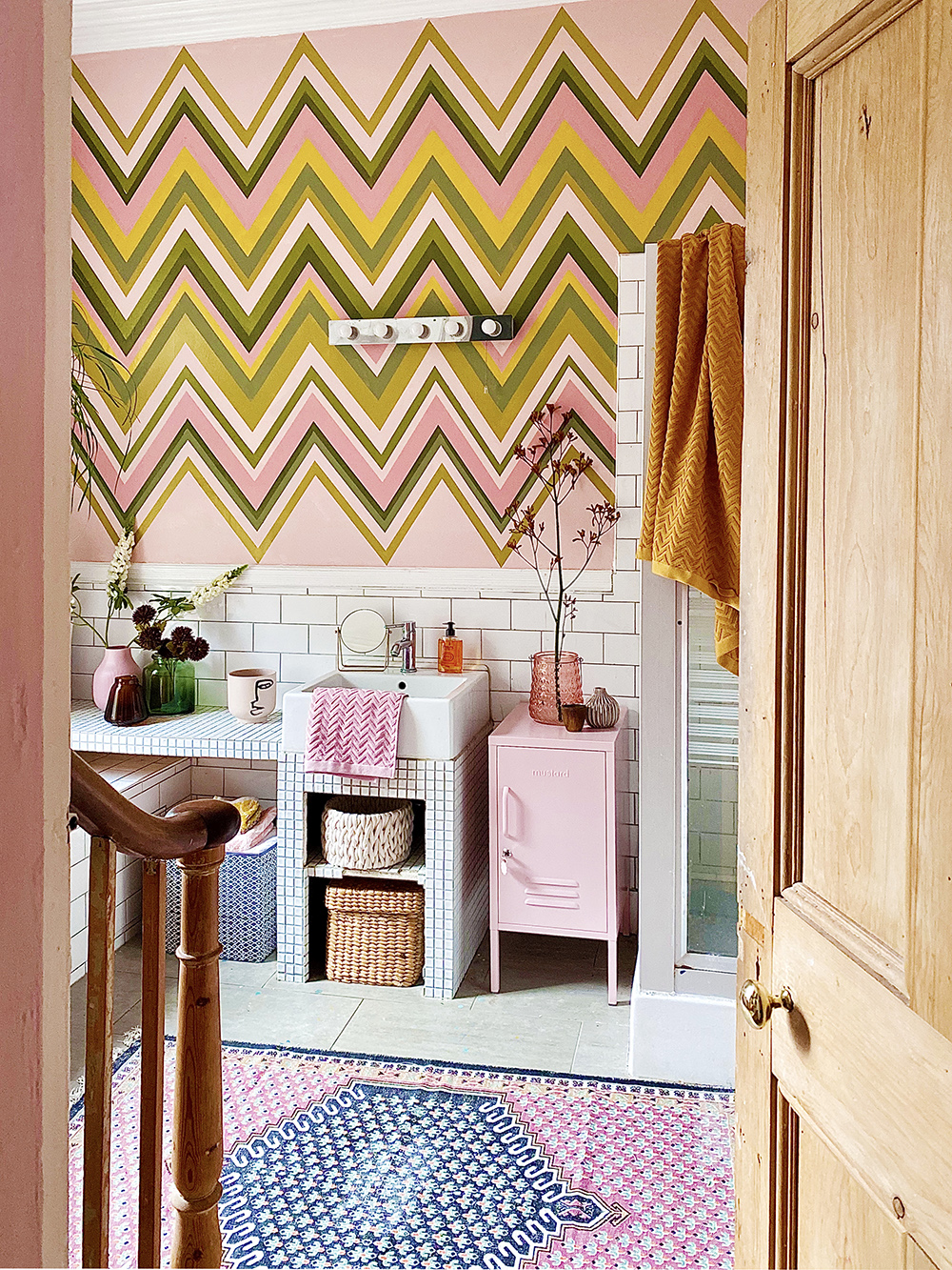 Pink bathroom decor with colourful zig zag wall mural
