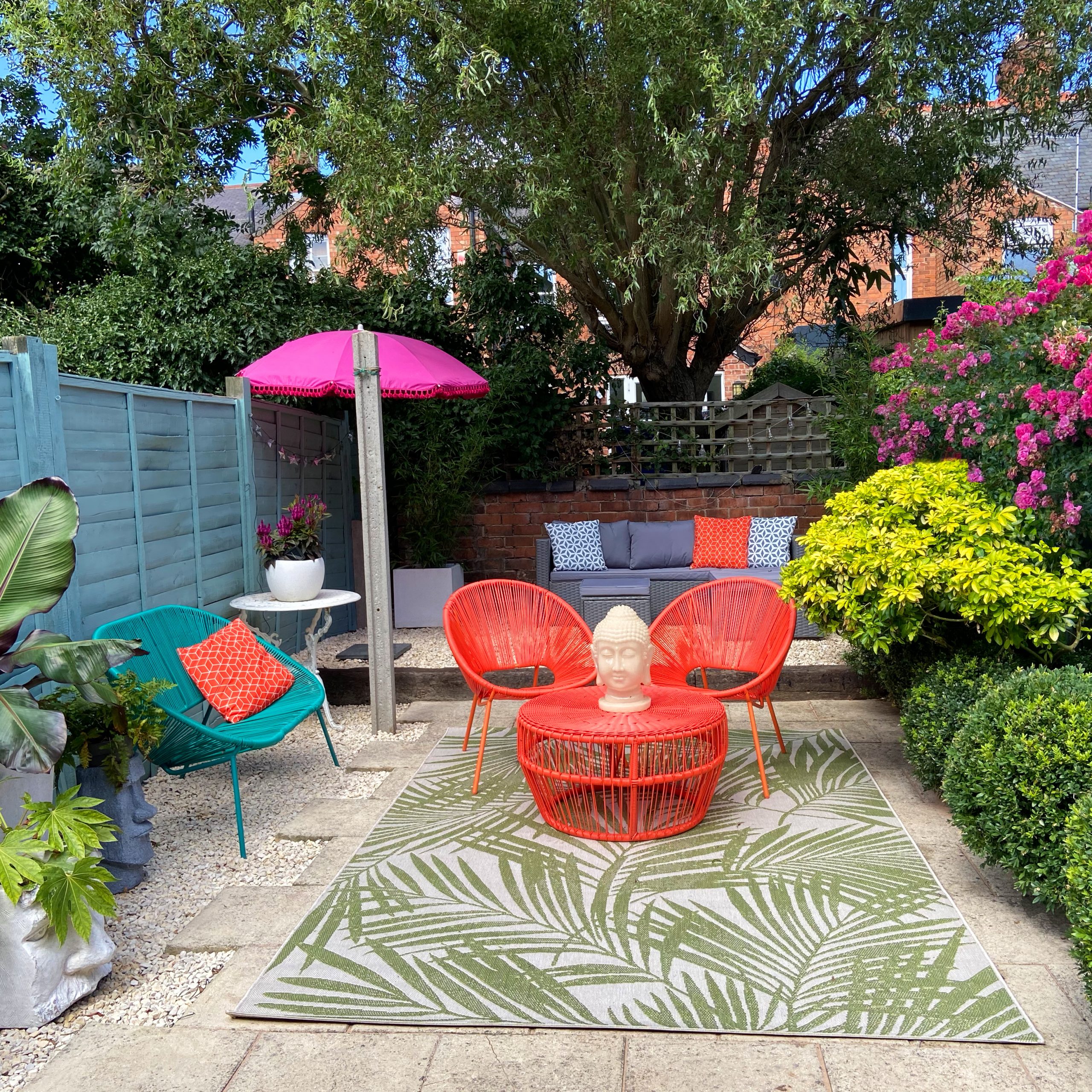 DIY gravel patio to create the feel of a Mediterranean courtyard, with colourful garden furniture and outdoor rug