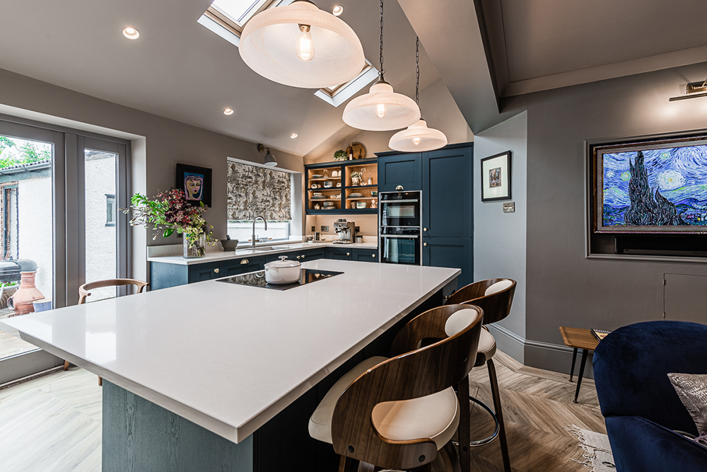 Contemporary kitchen design with navy blue cupboards, brass handles and large kitchen island