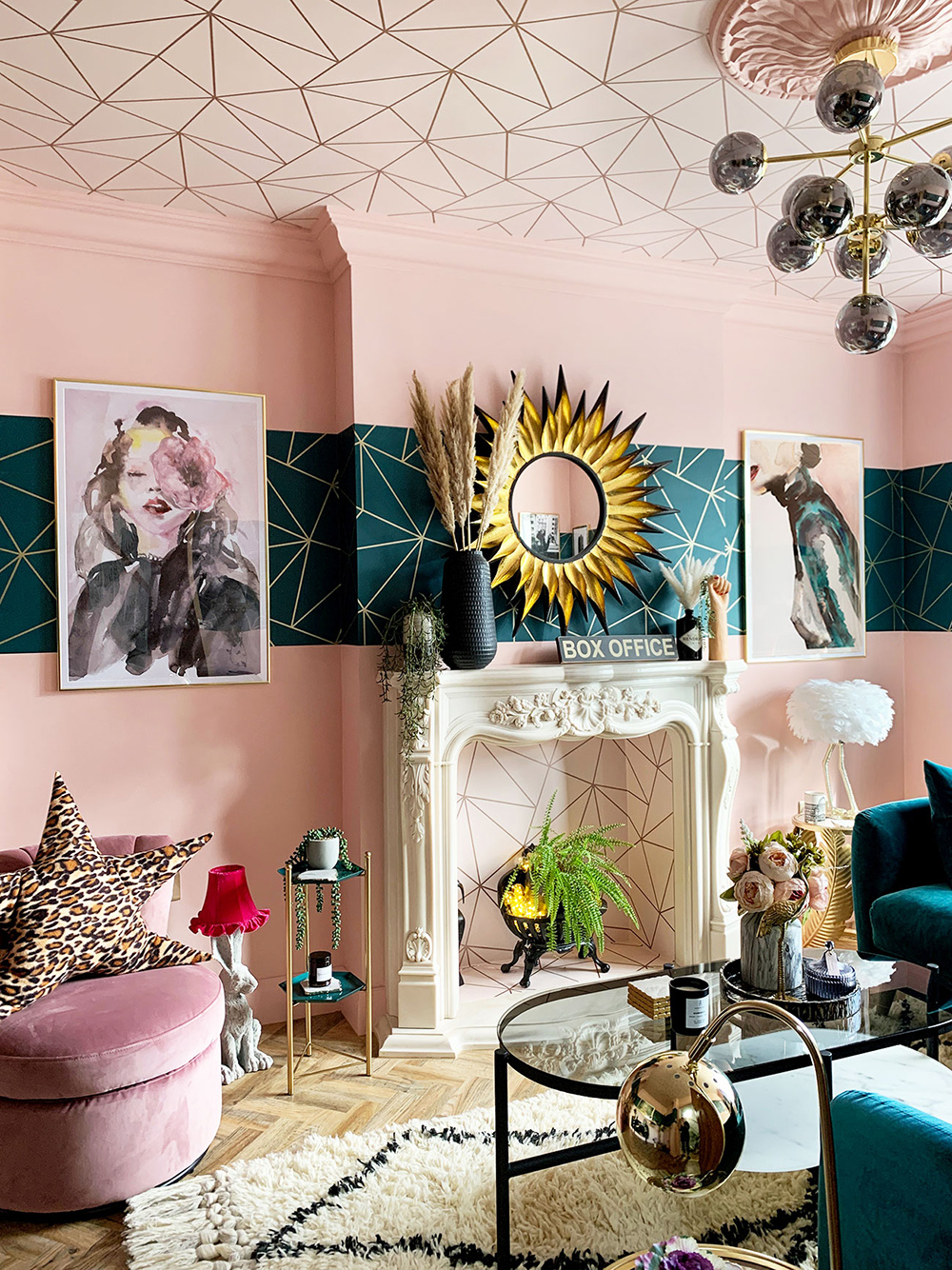 Pink and teal eclectic living room with geometric wallpaper and velvet furniture