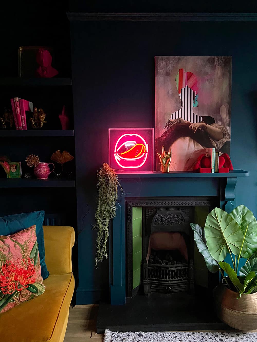 Quirky living room with dark, moody walls and colourful home accessories like the pink neon lips