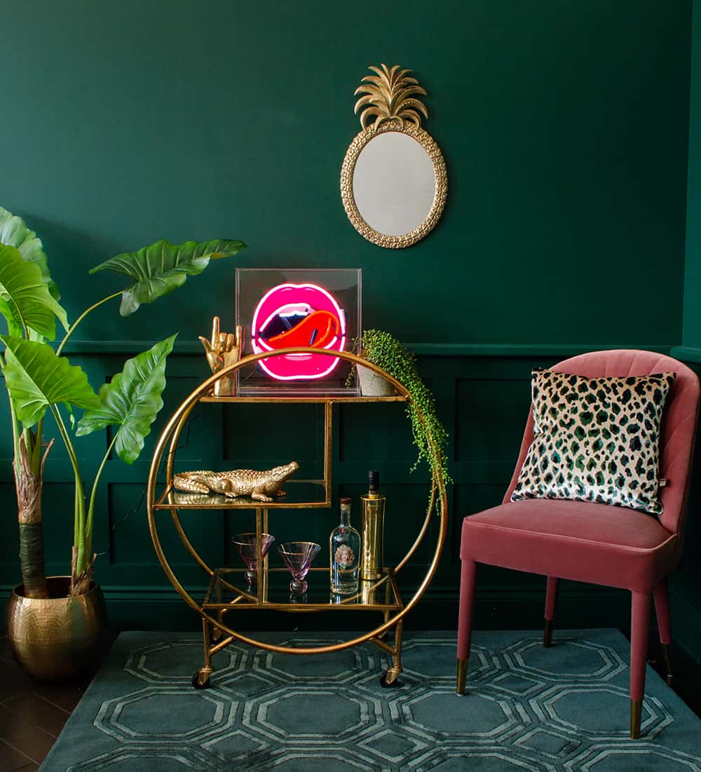 Gold round drinks trolley styling inspiration with neon ligh, gold rock on hand and cool barware