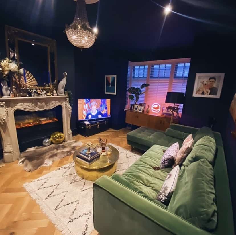 Navy blue living room with green velvet sofa and quirky home accessories
