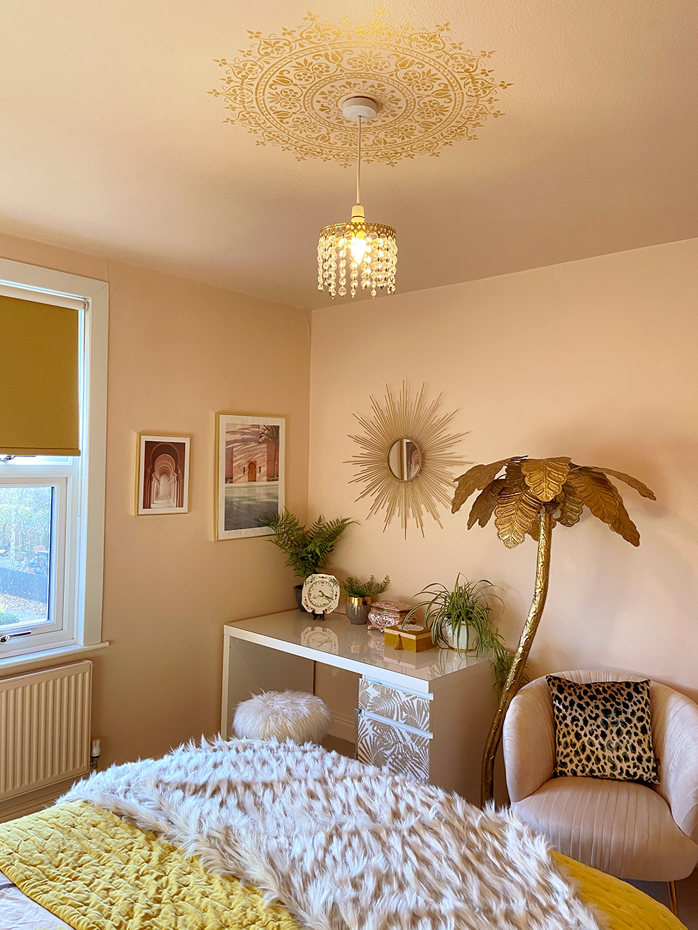 Gold ceiling medallion stencil in blush pink bedroom with gold accessories