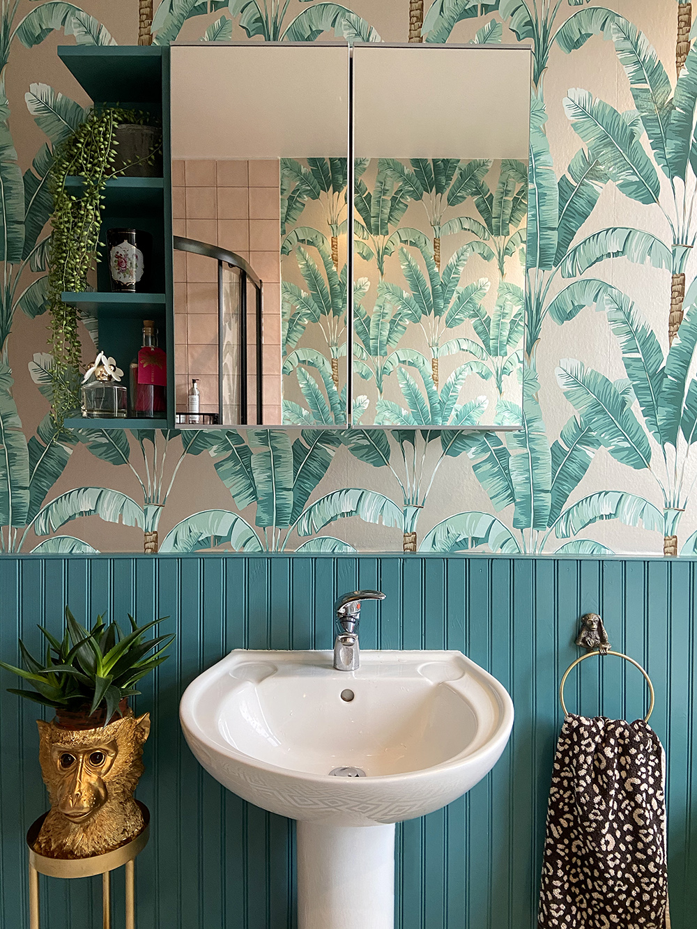 Tropical bathroom with Palmaria wallpaper by Osborne & Little and teal panelling