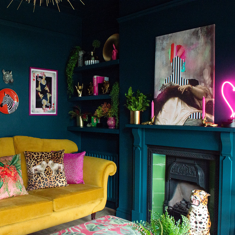 Dark and moody blue living room with pops of pink, colourful, quirky artwork and mustard yellow velvet sofa
