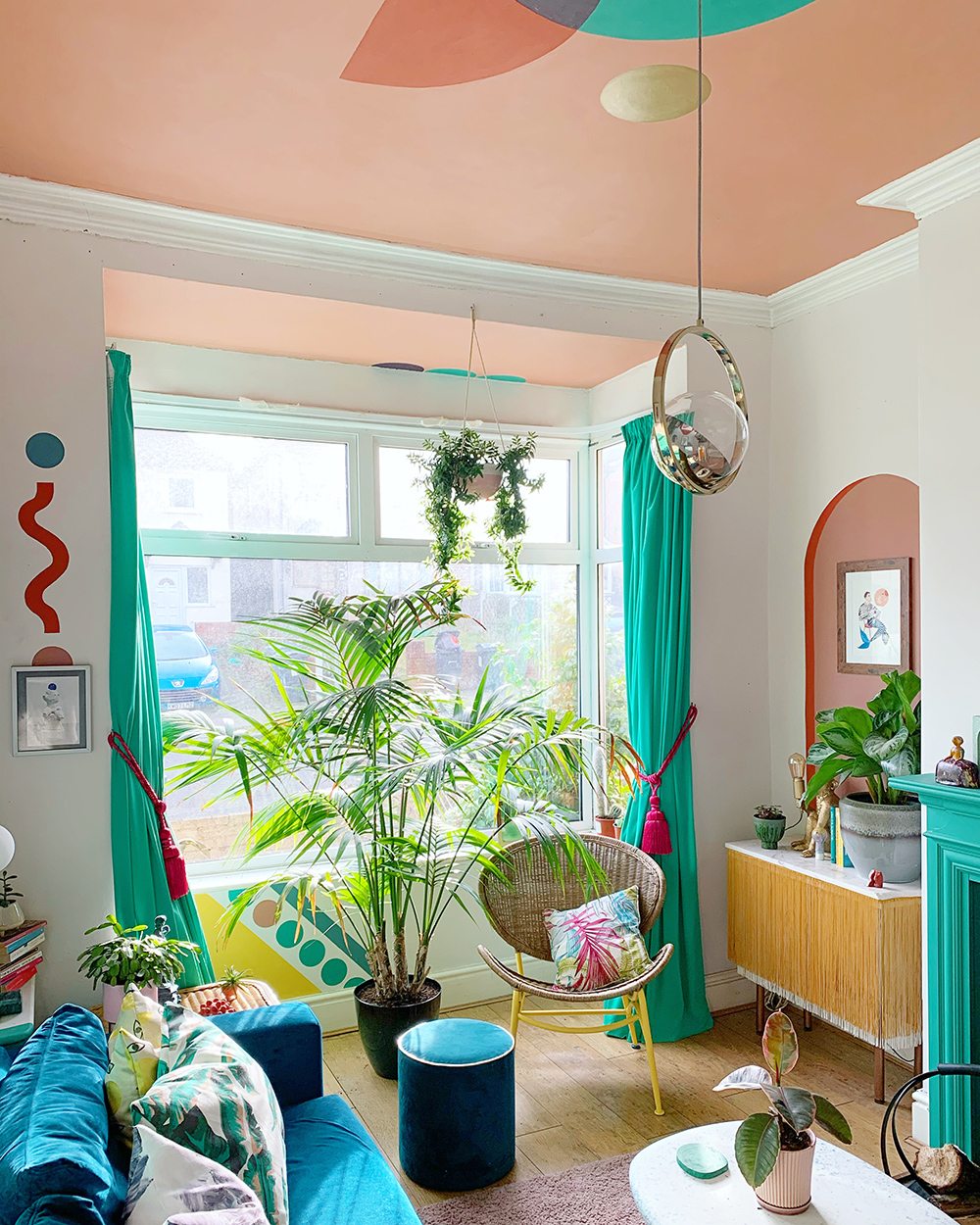 Teal and pink living room with unusual paint effect, ceiling mural and lots of lush house plants