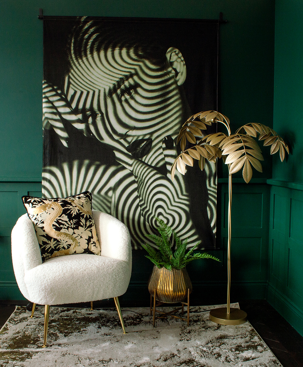 Dark green living room decor, with a monochrome, dramatic velvet wall hanging