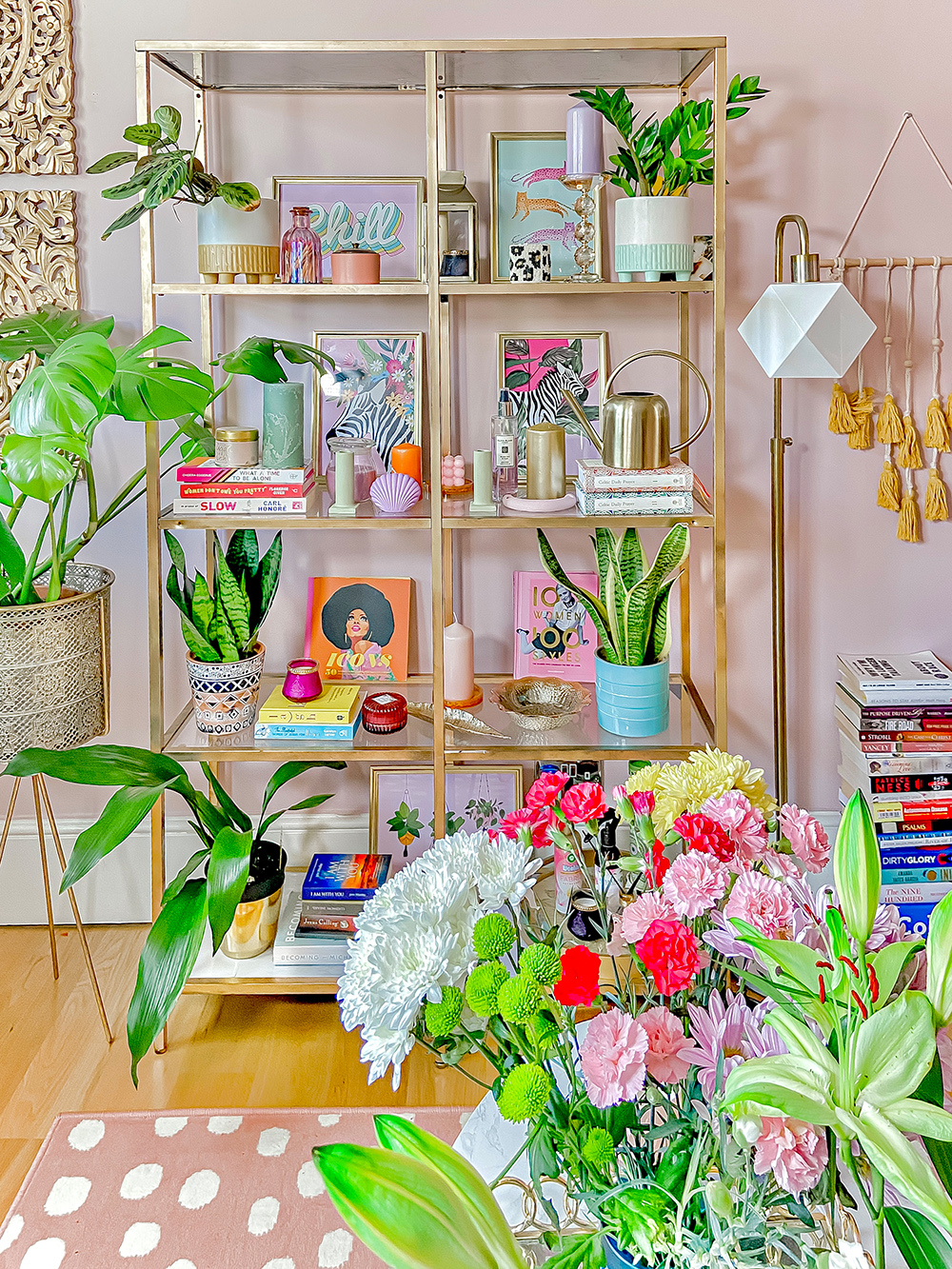 Shelf styling inspiration with lots of house plants, quirky home accessories, and colourful art prints