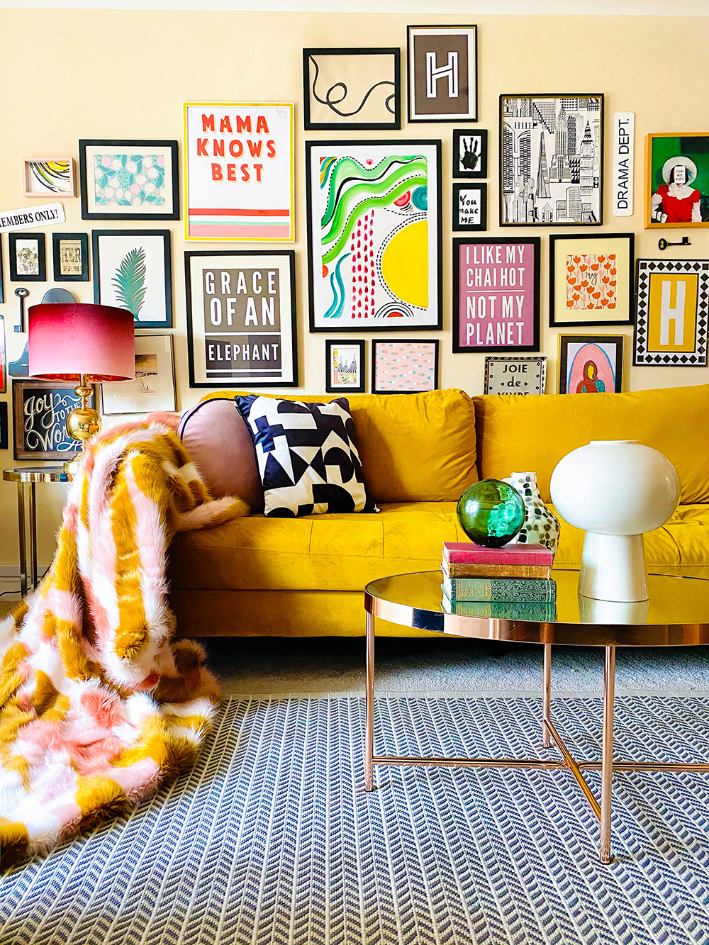 Quirky and colourful gallery wall with gorgeous mustard velvet sofa and colourful accessories.