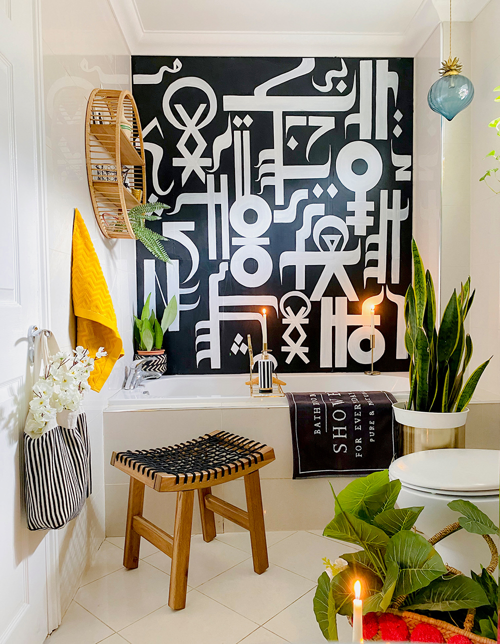 Monochrome bathroom inspiration with pops of yellow, luscious house plants and quirky wall mural