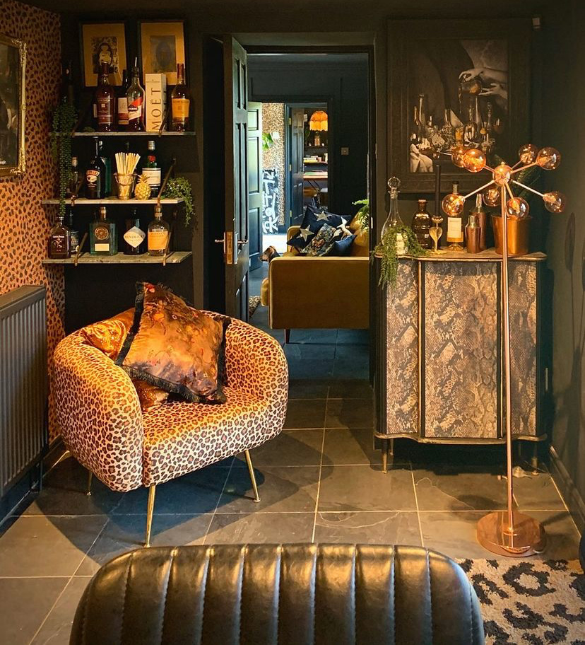 Dark and moody home bar by Sally Does Sassy. With leopard print wallpaper, armchairs and rug, what's not to love?!