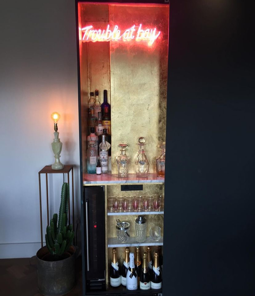 Gold leaf cocktail cupboard with pink neon sign