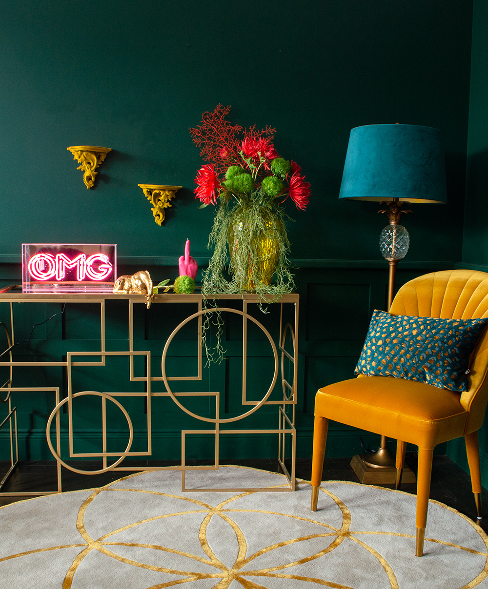 Colourful living room decor with pink OMG neon light, yellow velvet dining chair, gold console table and lots of quirky accessories. All available from Audenza
