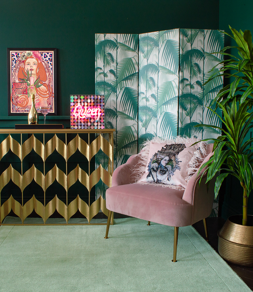 Glamorous and tropical living room decor with sequin queen neon light, gold console table and pink velvet armchair. All available from Audenza