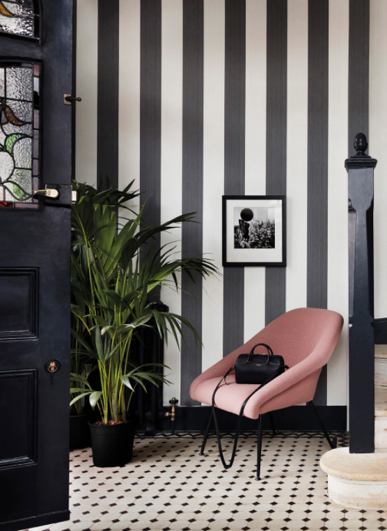 Monochrome hallway with black striped wallpaper by Cole & Son, and blush pink velvet chair