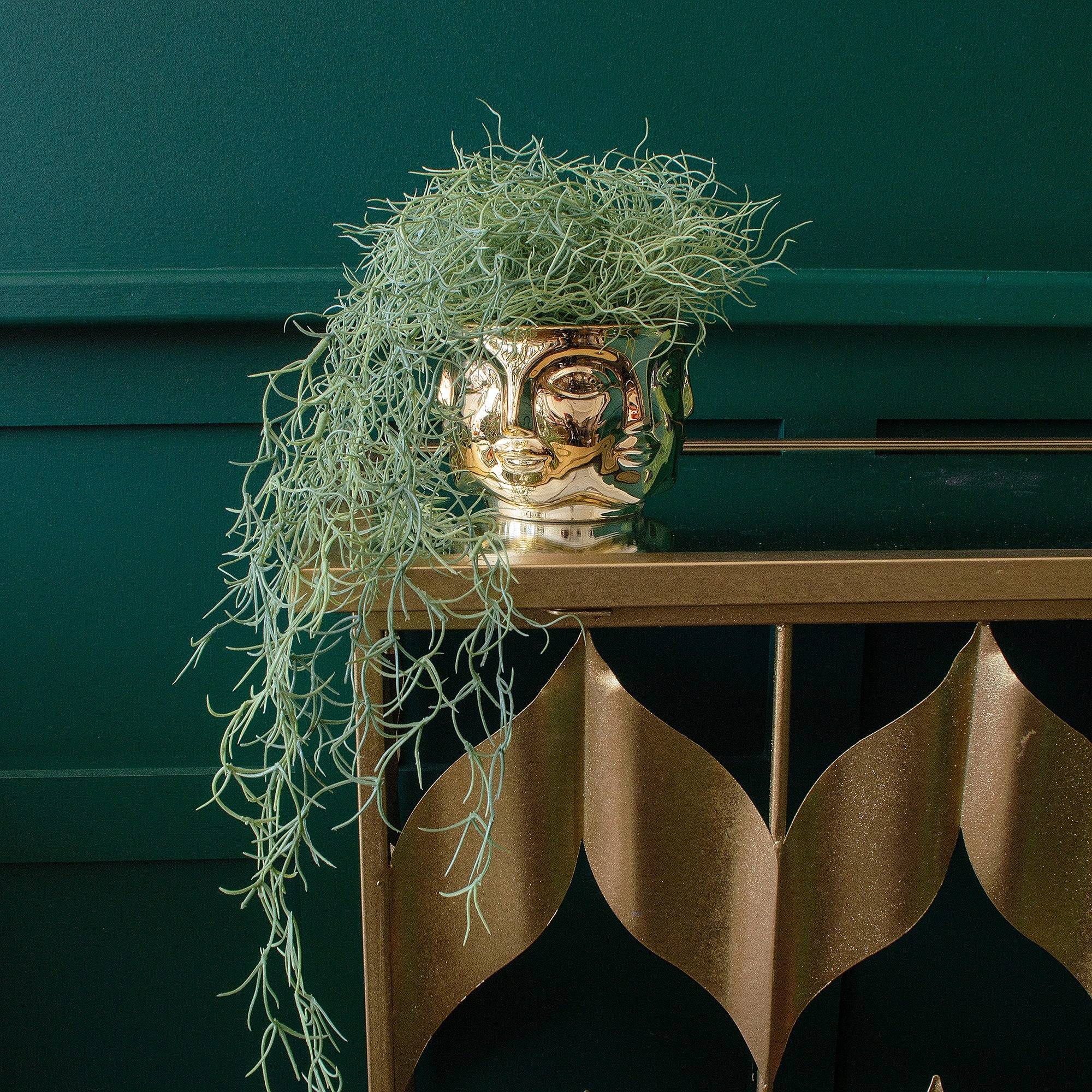 A faux potted trailing spanish moss placed on a console table